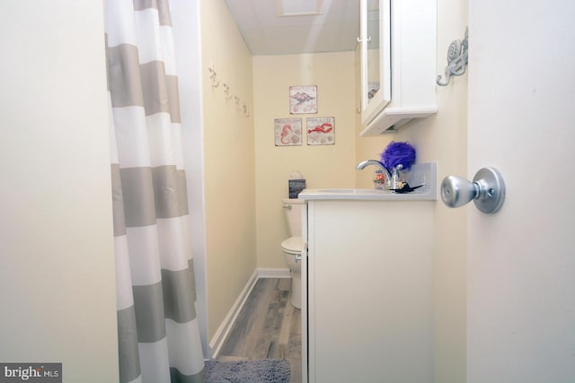 bathroom featuring sink, walk in shower, hardwood / wood-style flooring, and toilet