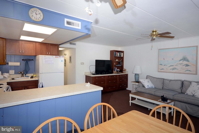 kitchen featuring ceiling fan, white refrigerator, and sink