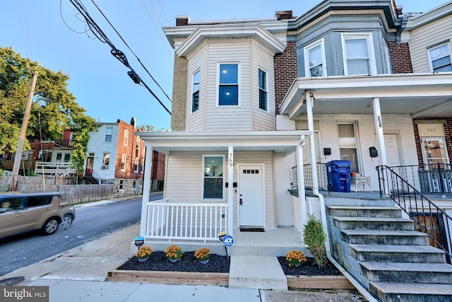 townhome / multi-family property featuring covered porch