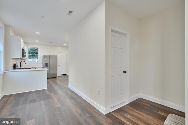 kitchen featuring sink, dark wood-type flooring, appliances with stainless steel finishes, and white cabinets