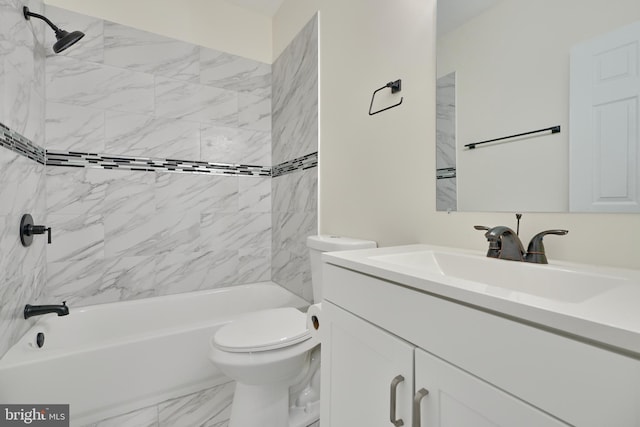 full bathroom featuring vanity, tiled shower / bath, and toilet