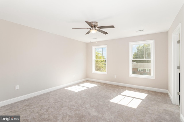 carpeted spare room featuring ceiling fan