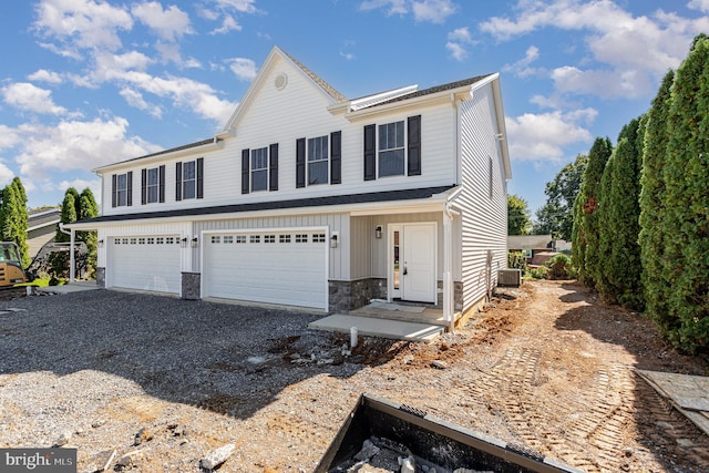 view of front of home featuring a garage and central air condition unit