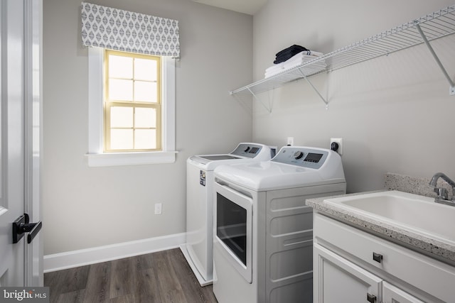 clothes washing area featuring independent washer and dryer, cabinets, sink, and dark hardwood / wood-style floors