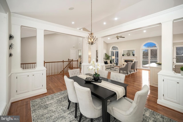 dining space featuring ceiling fan, dark wood-type flooring, ornate columns, and vaulted ceiling