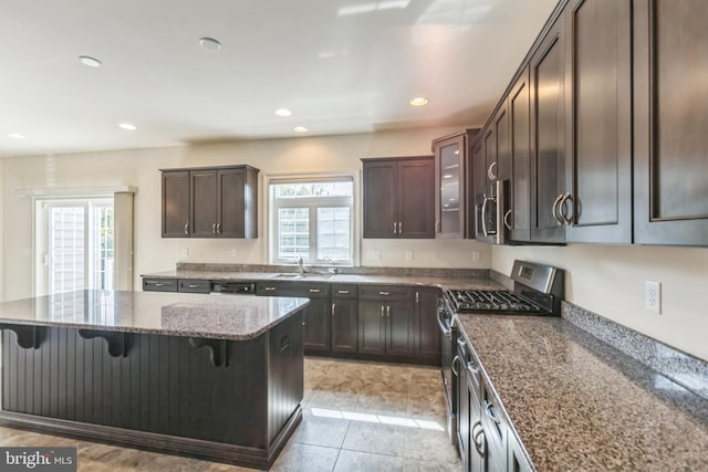 kitchen with sink, appliances with stainless steel finishes, a kitchen bar, and a healthy amount of sunlight