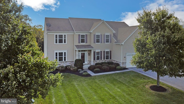 view of front of property featuring a garage and a front yard