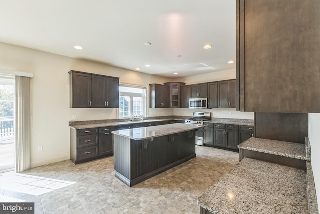 kitchen featuring appliances with stainless steel finishes, plenty of natural light, a kitchen breakfast bar, and a center island