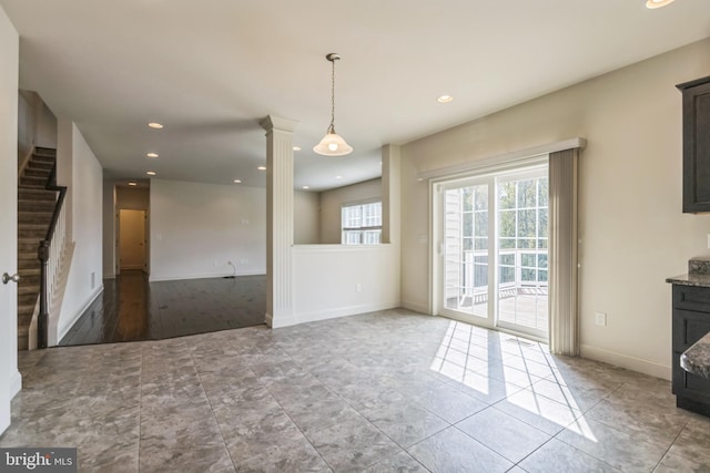 unfurnished dining area featuring light hardwood / wood-style flooring and ornate columns