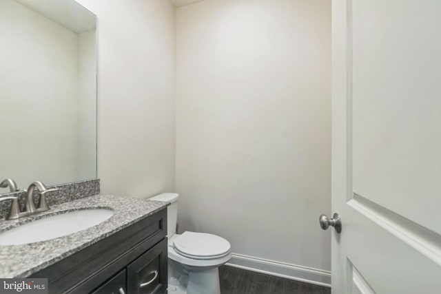 bathroom featuring vanity, toilet, and hardwood / wood-style flooring