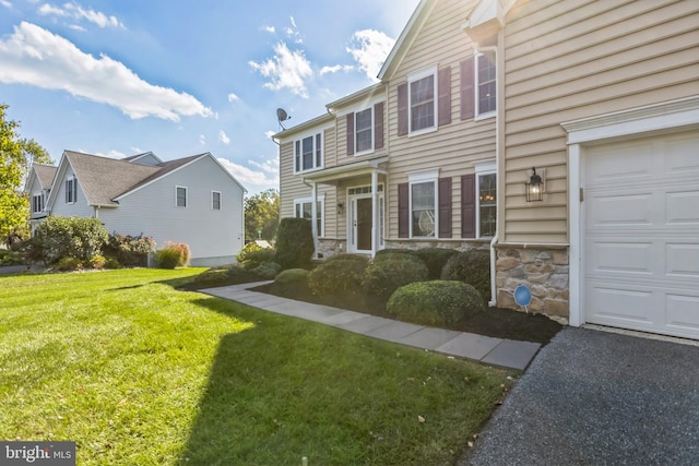 view of front of property featuring a front lawn and a garage