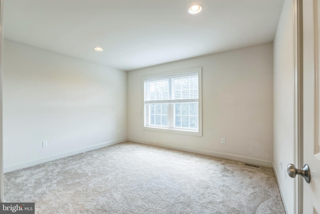 unfurnished room featuring light carpet