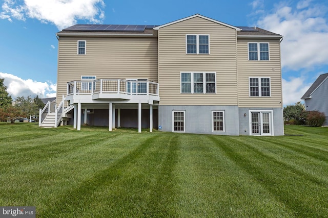 back of house featuring a wooden deck and a lawn