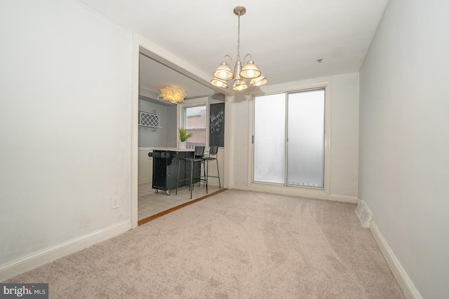 interior space featuring an inviting chandelier, carpet flooring, baseboards, and visible vents