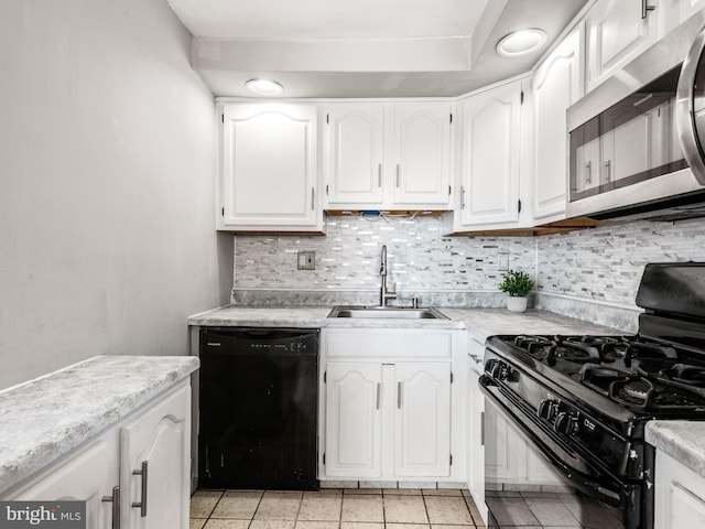 kitchen with decorative backsplash, white cabinets, a sink, light countertops, and black appliances