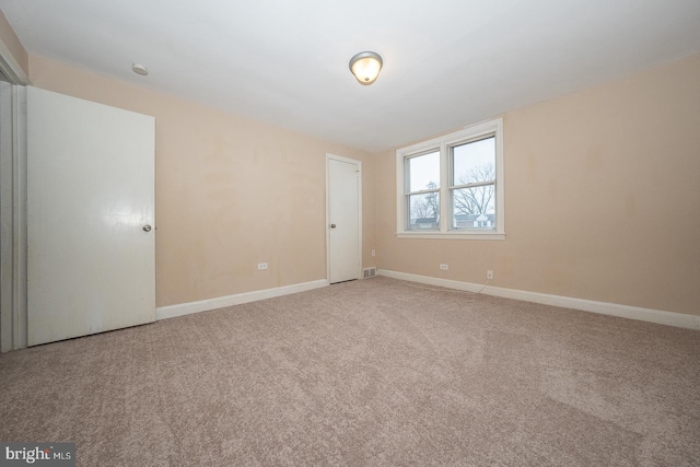 unfurnished room with baseboards, visible vents, and carpet