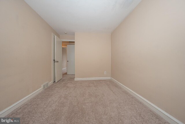unfurnished room featuring visible vents, light carpet, and baseboards