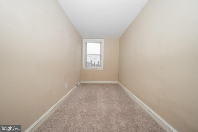 unfurnished room featuring baseboards and carpet