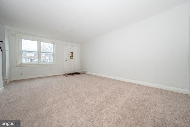spare room featuring baseboards and carpet floors