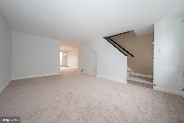 bonus room with a chandelier, baseboards, stairs, and carpet