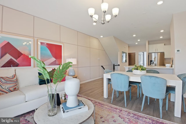 living room featuring wood-type flooring and an inviting chandelier