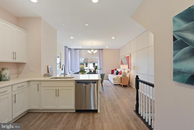 kitchen with light wood-type flooring, sink, dishwasher, hanging light fixtures, and white cabinets