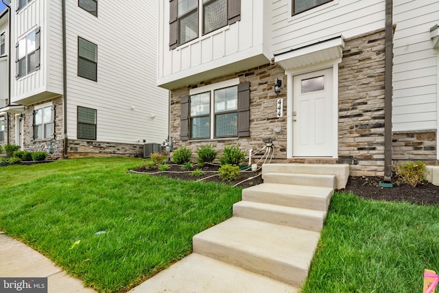 property entrance featuring a lawn and central AC