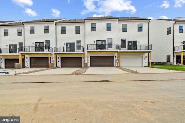 view of front facade with central air condition unit, a garage, and a balcony