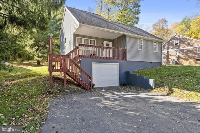 view of front of home with a garage and central AC