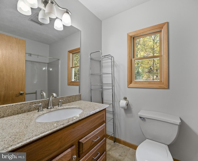 bathroom with vanity, walk in shower, and toilet