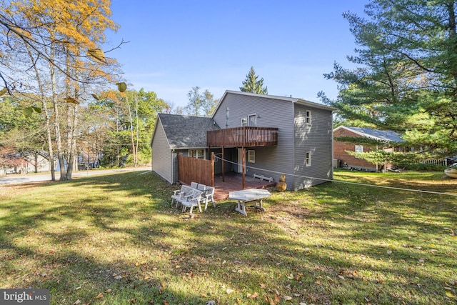 rear view of property with a yard and a wooden deck