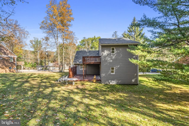 rear view of property featuring a deck and a yard