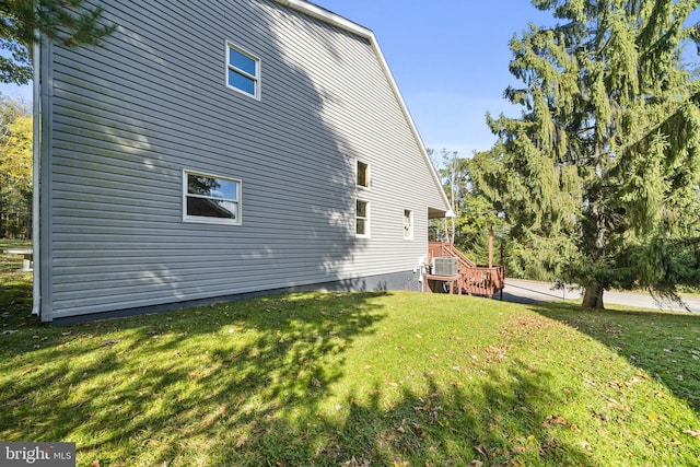 view of property exterior featuring a yard and central AC