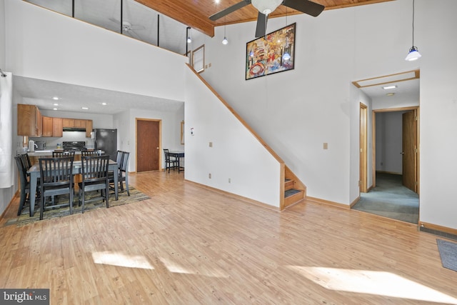 unfurnished living room featuring light wood-type flooring, high vaulted ceiling, wooden ceiling, and beamed ceiling