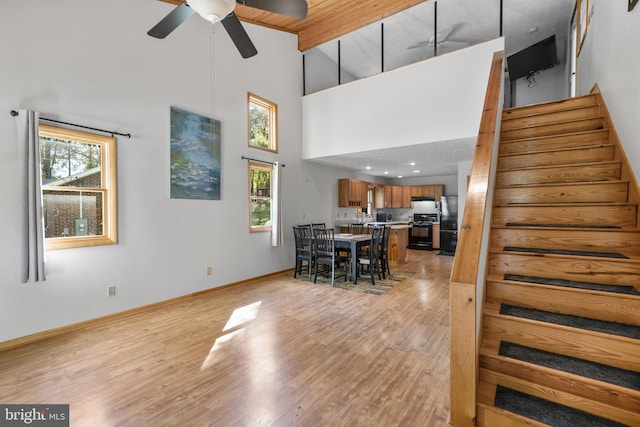 dining area with ceiling fan, high vaulted ceiling, light hardwood / wood-style flooring, and a healthy amount of sunlight