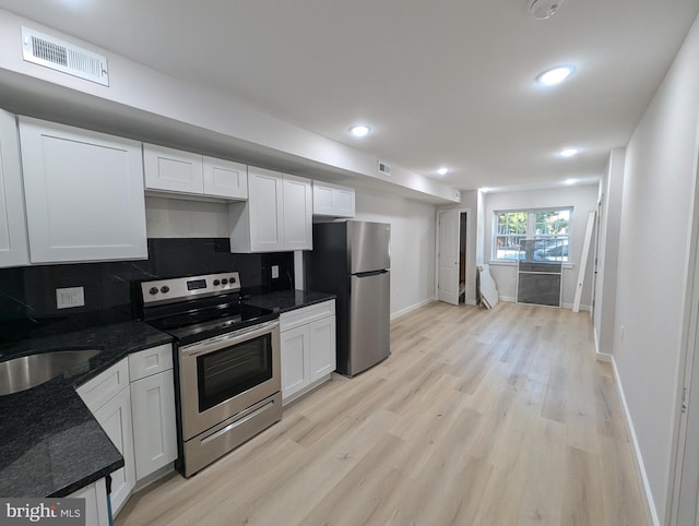 kitchen with white cabinetry, light hardwood / wood-style flooring, stainless steel appliances, and tasteful backsplash