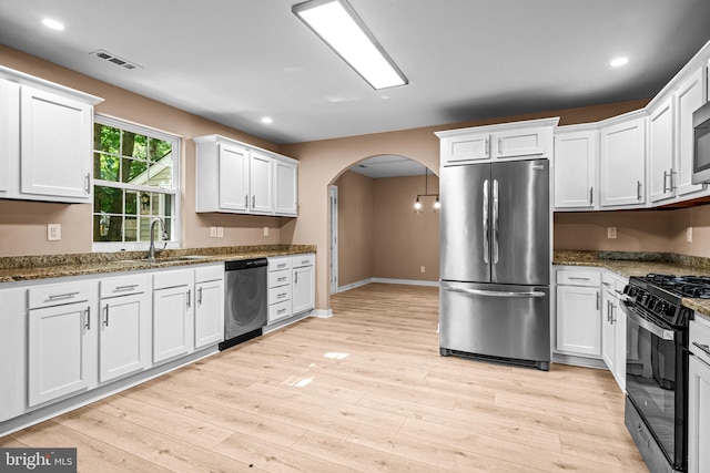 kitchen featuring white cabinets, stainless steel appliances, sink, and light hardwood / wood-style flooring