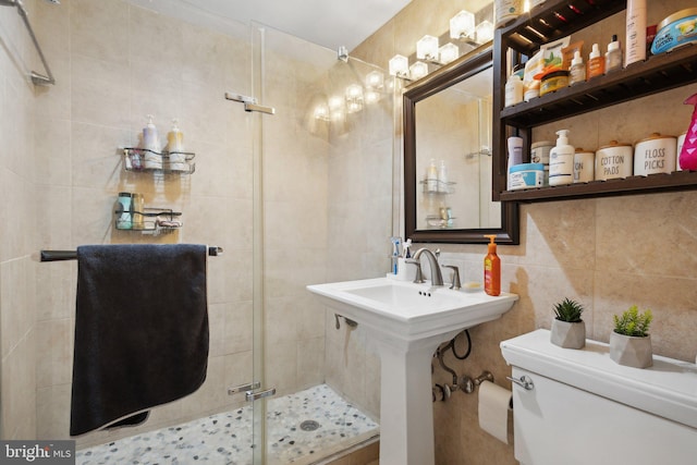 bathroom with decorative backsplash, tile walls, an enclosed shower, and toilet