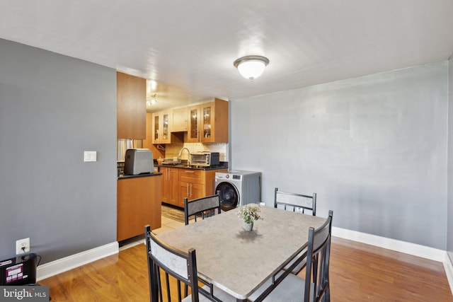 dining area with light wood-type flooring and washer / clothes dryer