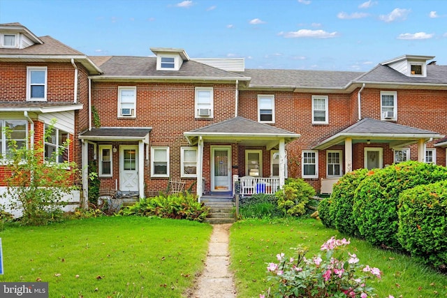 view of property featuring a front lawn and covered porch