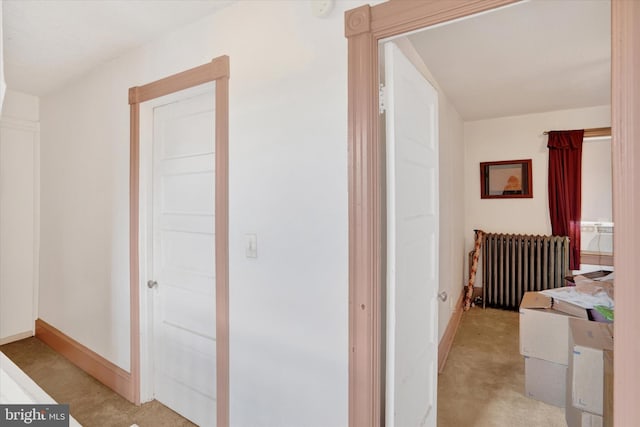 hallway with light carpet and radiator heating unit