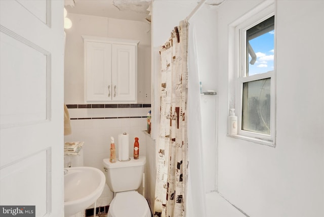 bathroom featuring toilet, tile walls, sink, and a shower with shower curtain