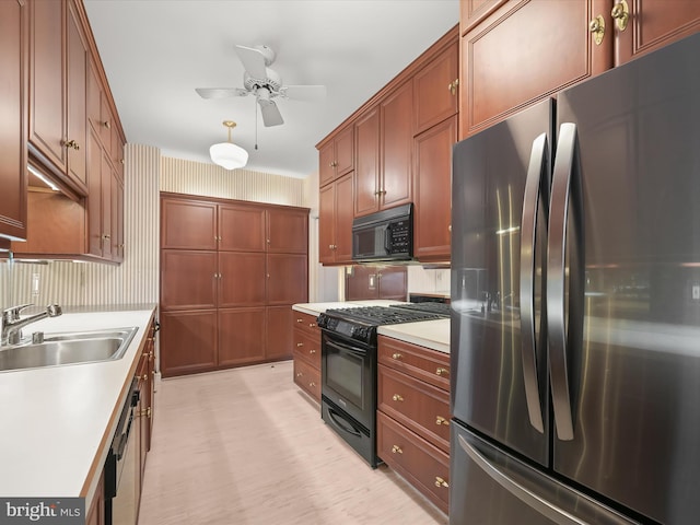 kitchen with a ceiling fan, black appliances, light countertops, and a sink