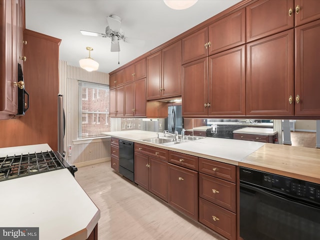 kitchen featuring a ceiling fan, black appliances, light countertops, and a sink