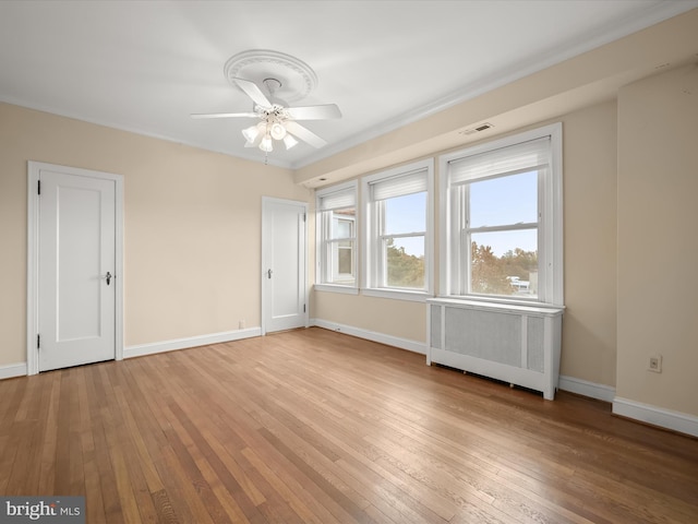 interior space with light wood finished floors, visible vents, radiator, and baseboards