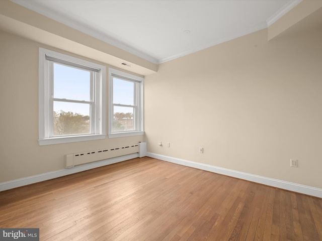 unfurnished room featuring visible vents, light wood-style flooring, ornamental molding, a baseboard radiator, and baseboards