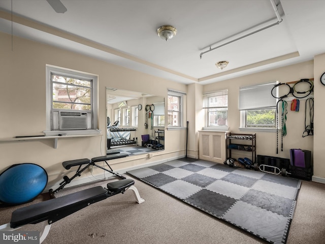 workout area featuring cooling unit, baseboards, and a raised ceiling