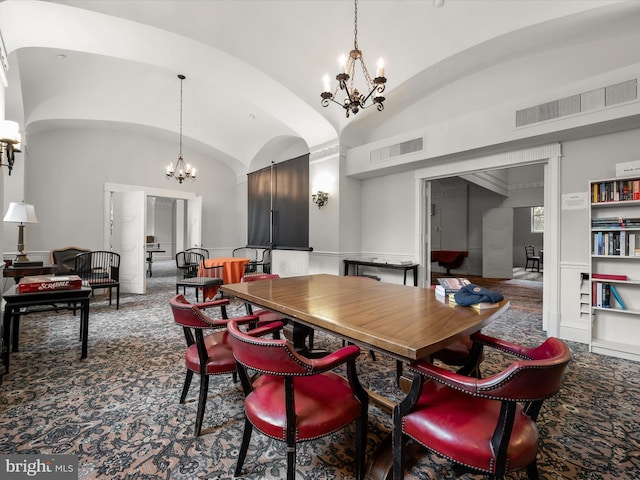 dining space featuring visible vents, a notable chandelier, and vaulted ceiling