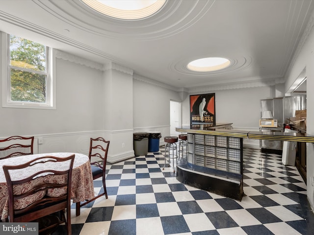 interior space featuring tile patterned floors, wainscoting, and ornamental molding