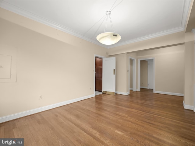 unfurnished room featuring ornamental molding, baseboards, and wood finished floors